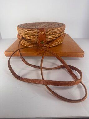 Handwoven round rattan and ata grass cross body bag.  Tag Amerii